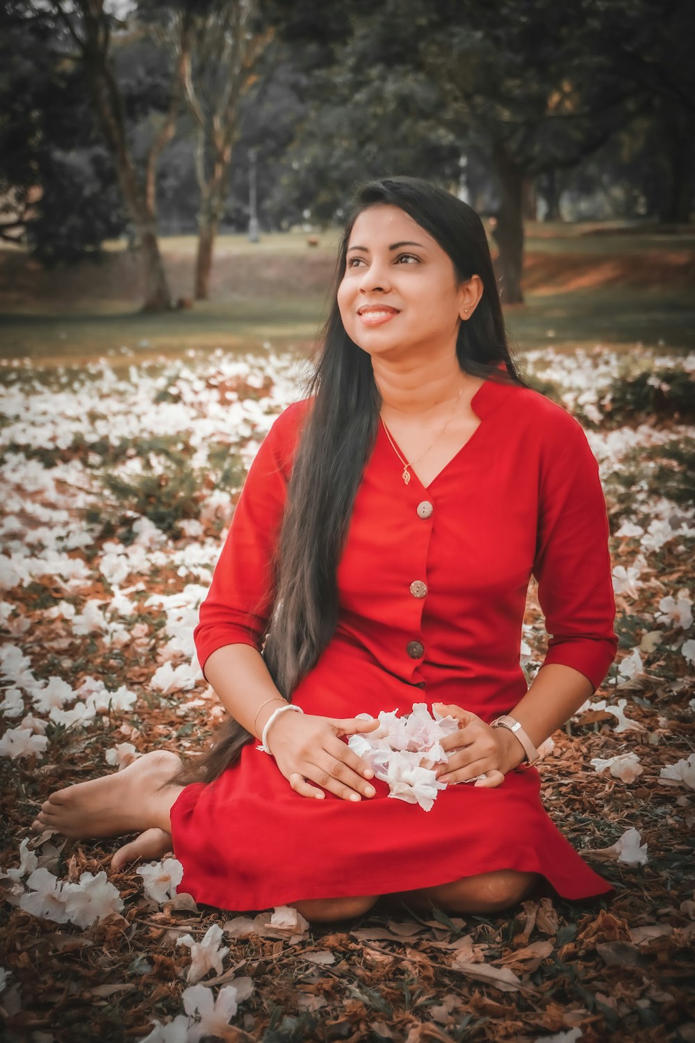 a woman in a red dress sitting on the ground