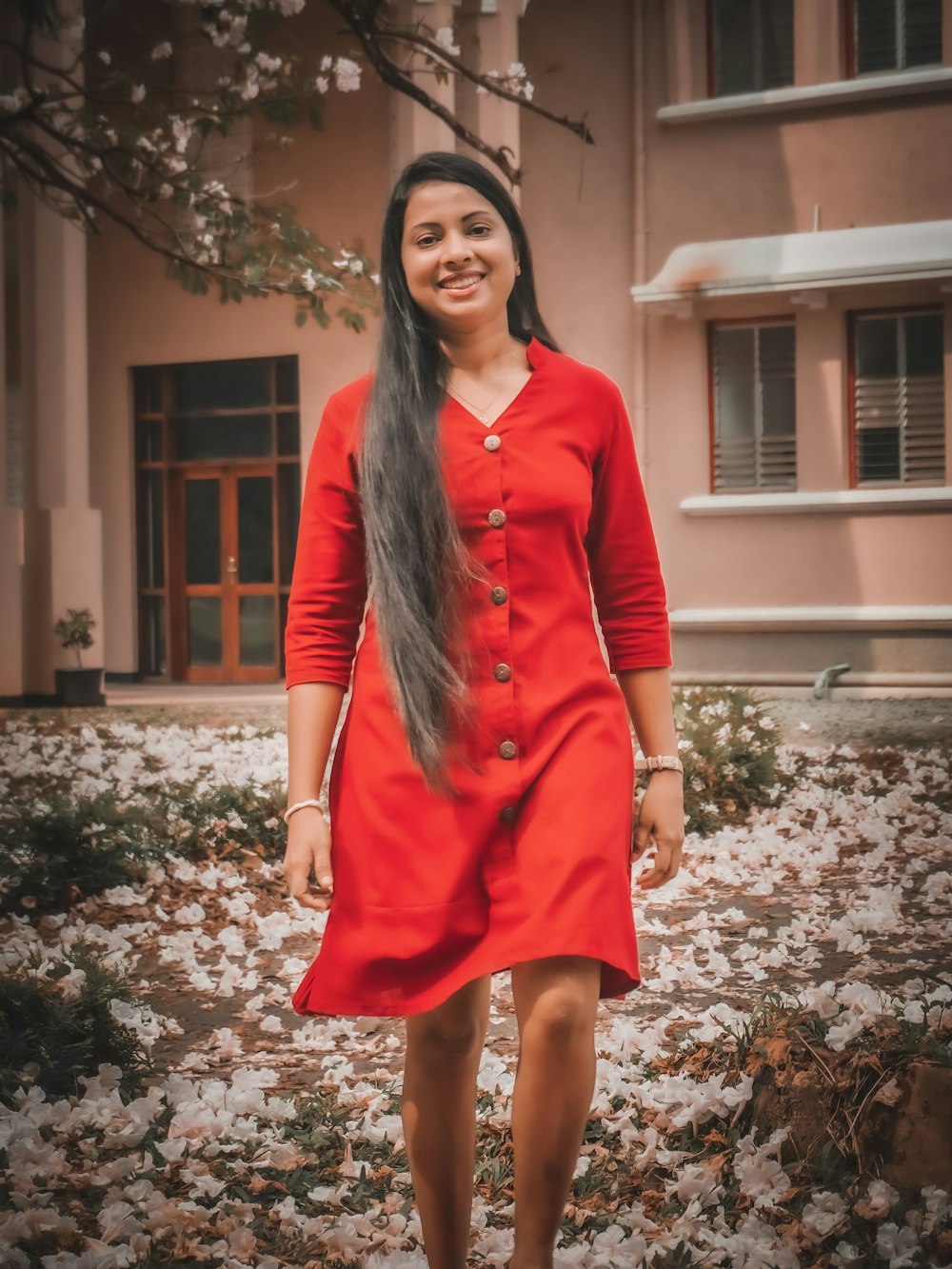 a woman in a red dress standing in front of a building