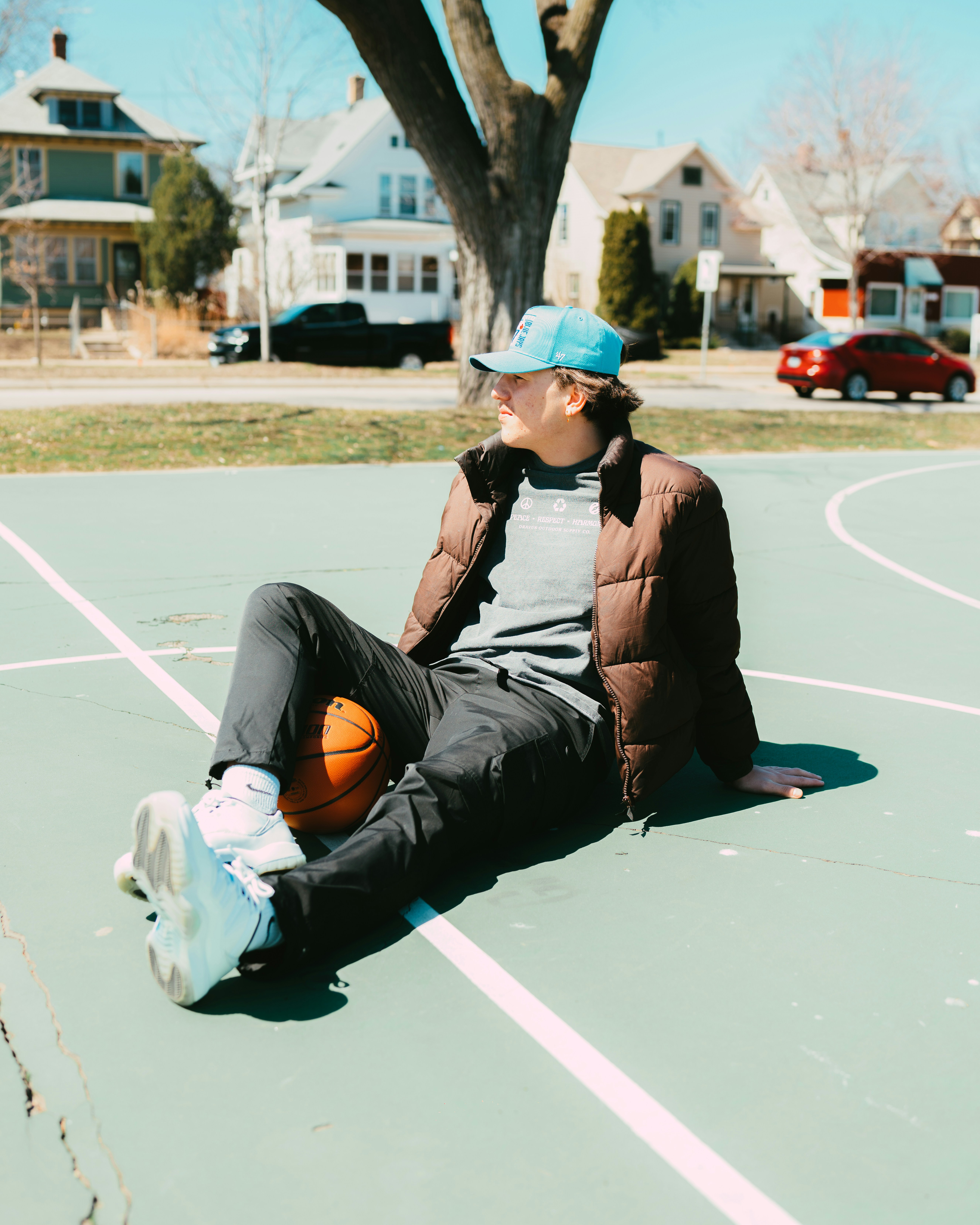 a young man sitting on a basketball court