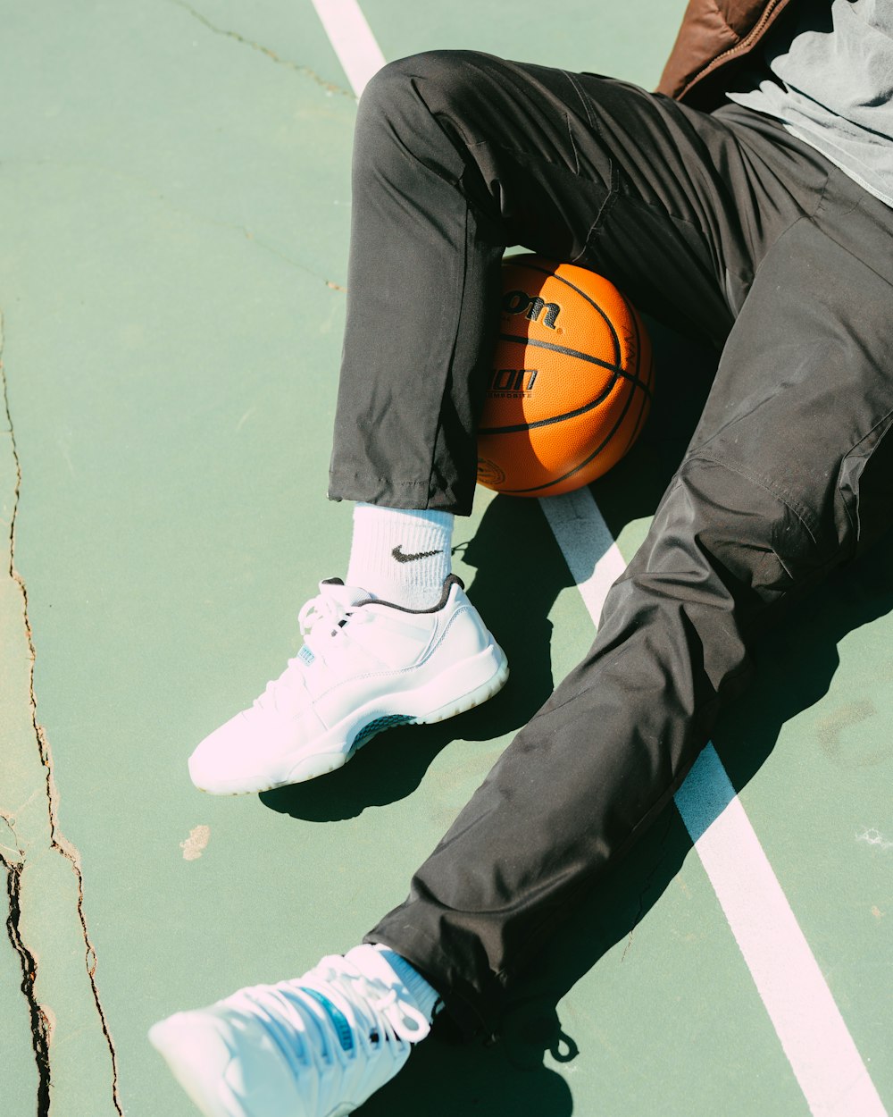 a man laying on a court with a basketball