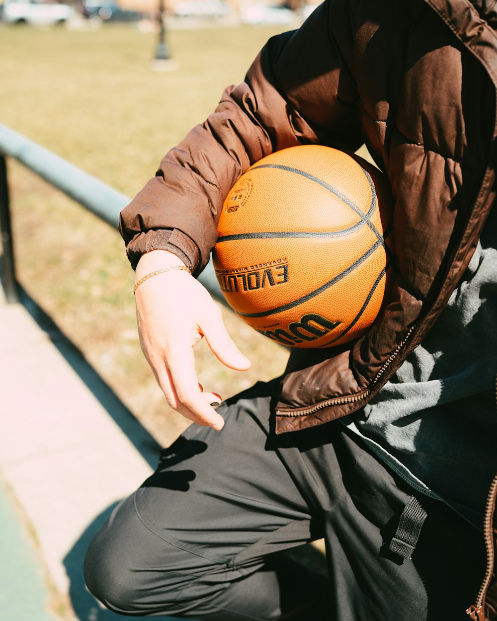 a person holding a basketball sitting on a bench