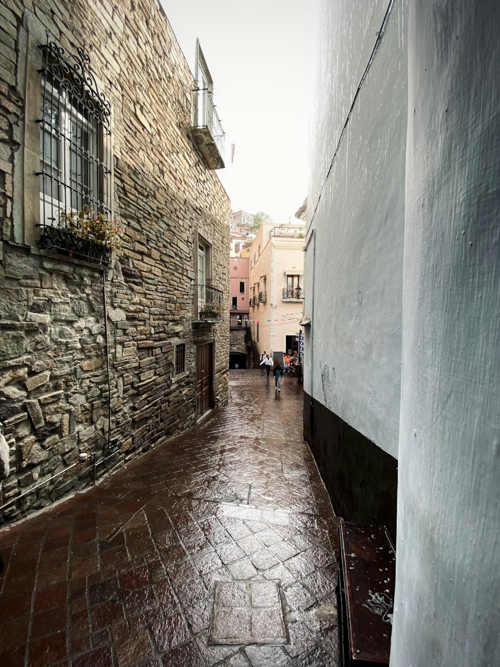 a cobblestone street with a stone building in the background