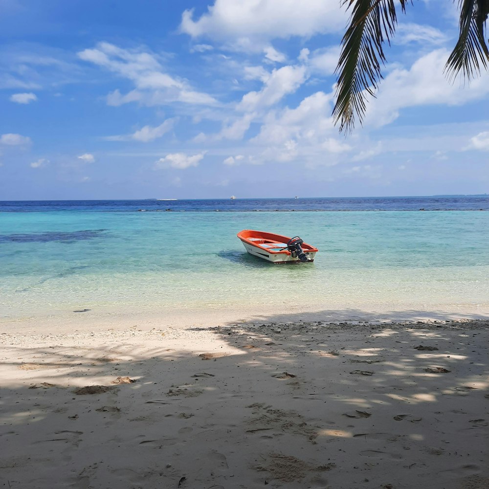 a small boat sitting on top of a sandy beach