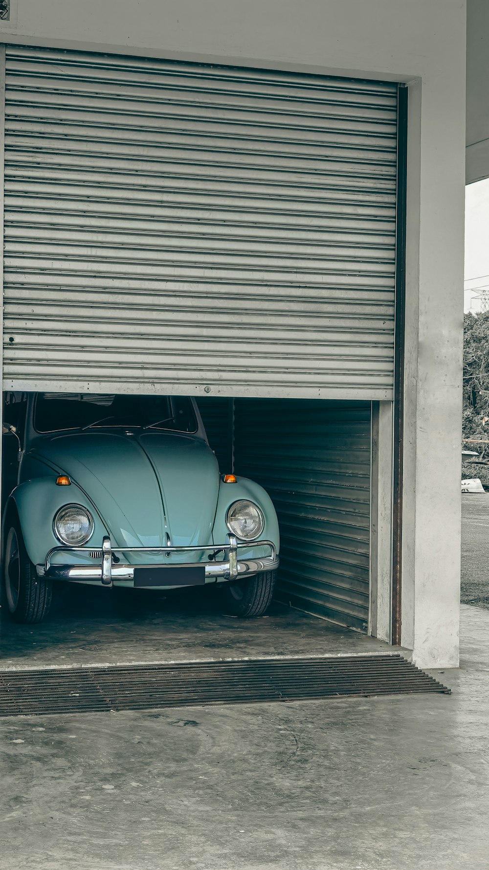 Un coche azul está aparcado en un garaje