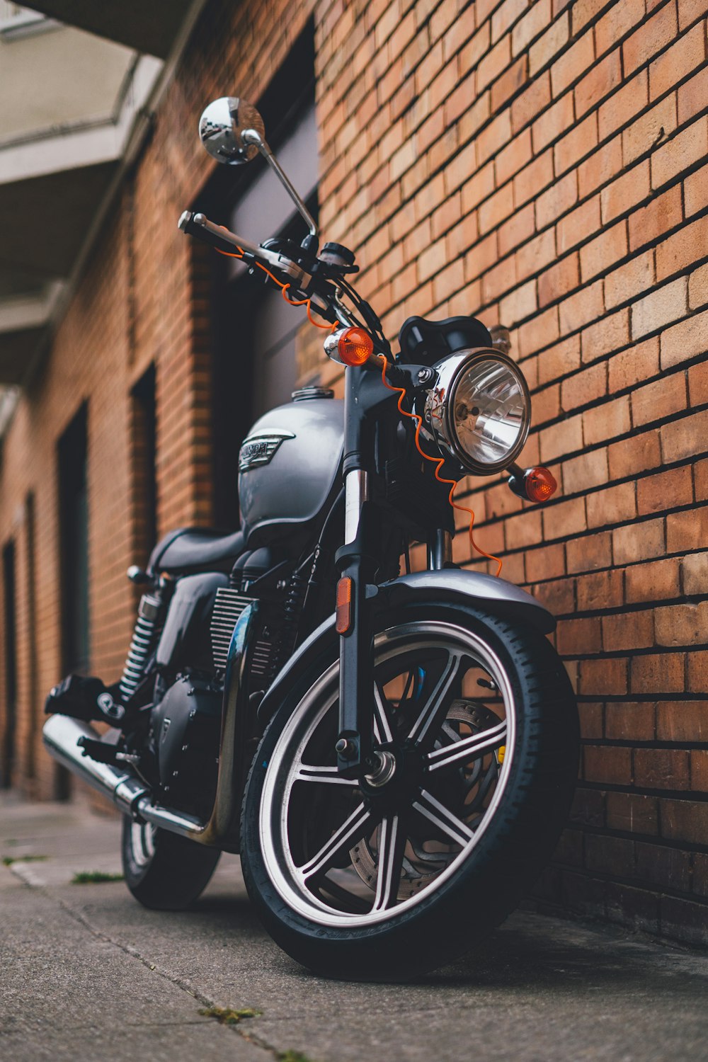 une moto garée à côté d’un mur de briques