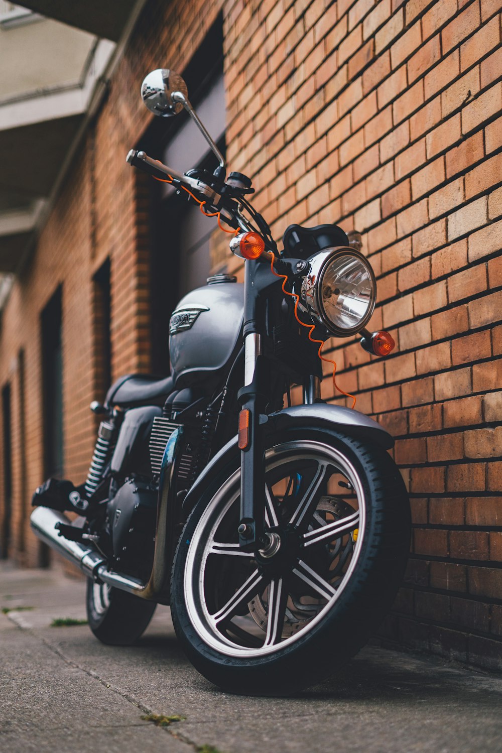 a motorcycle parked next to a brick wall