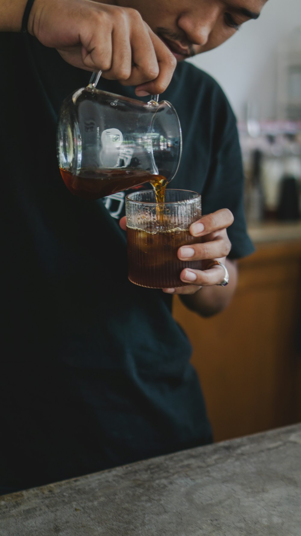 Ein Mann gießt ein Getränk in ein Glas