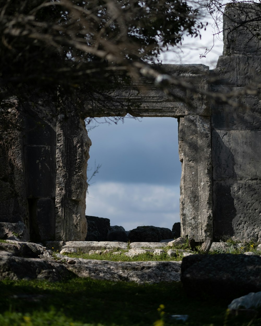 a view of the ocean through a stone archway