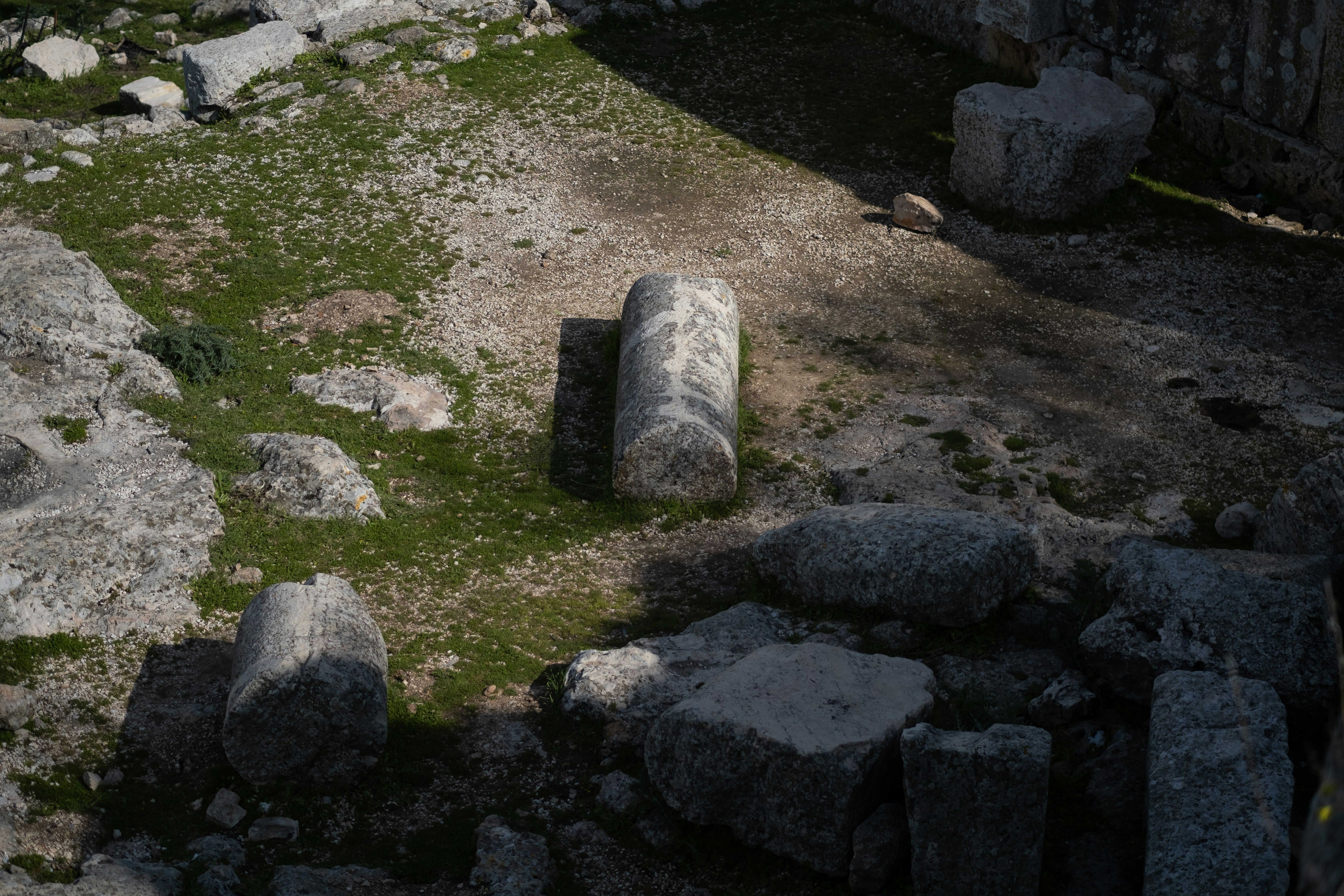 a large rock sitting on top of a lush green field
