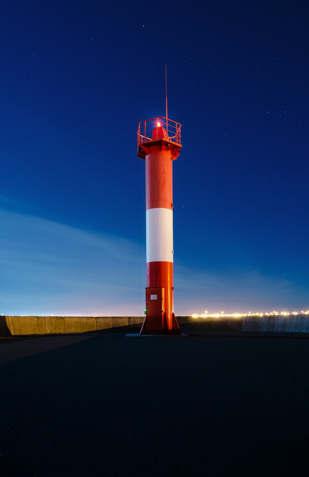 a red and white light house sitting on top of a hill