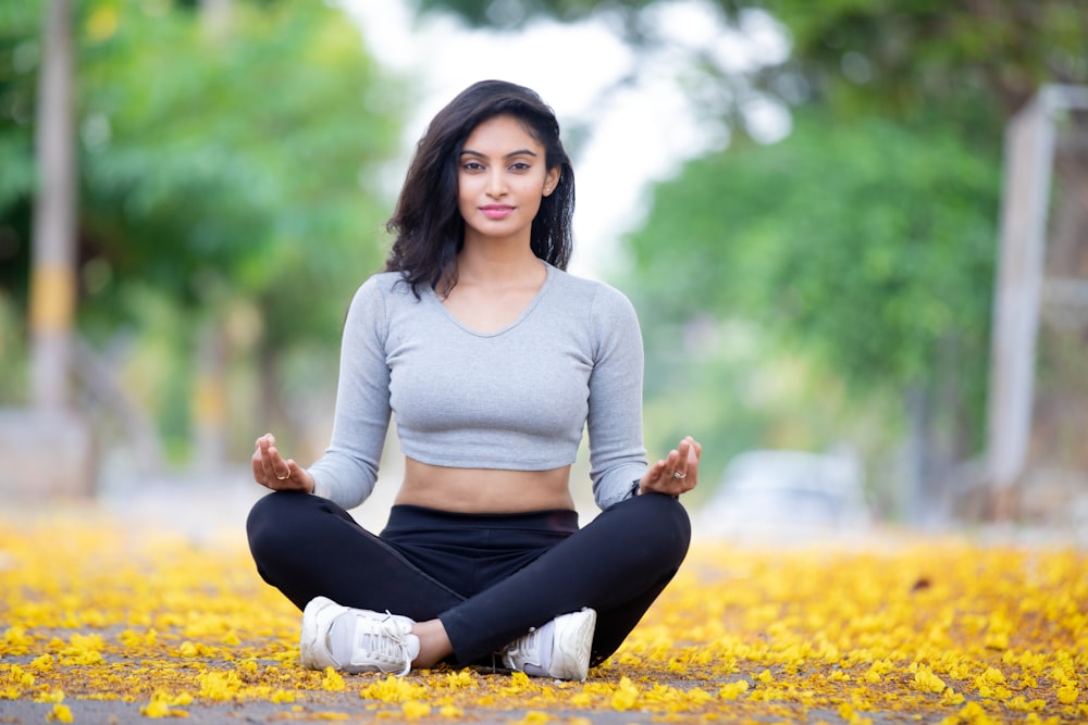 a woman sitting in a yoga position on the ground