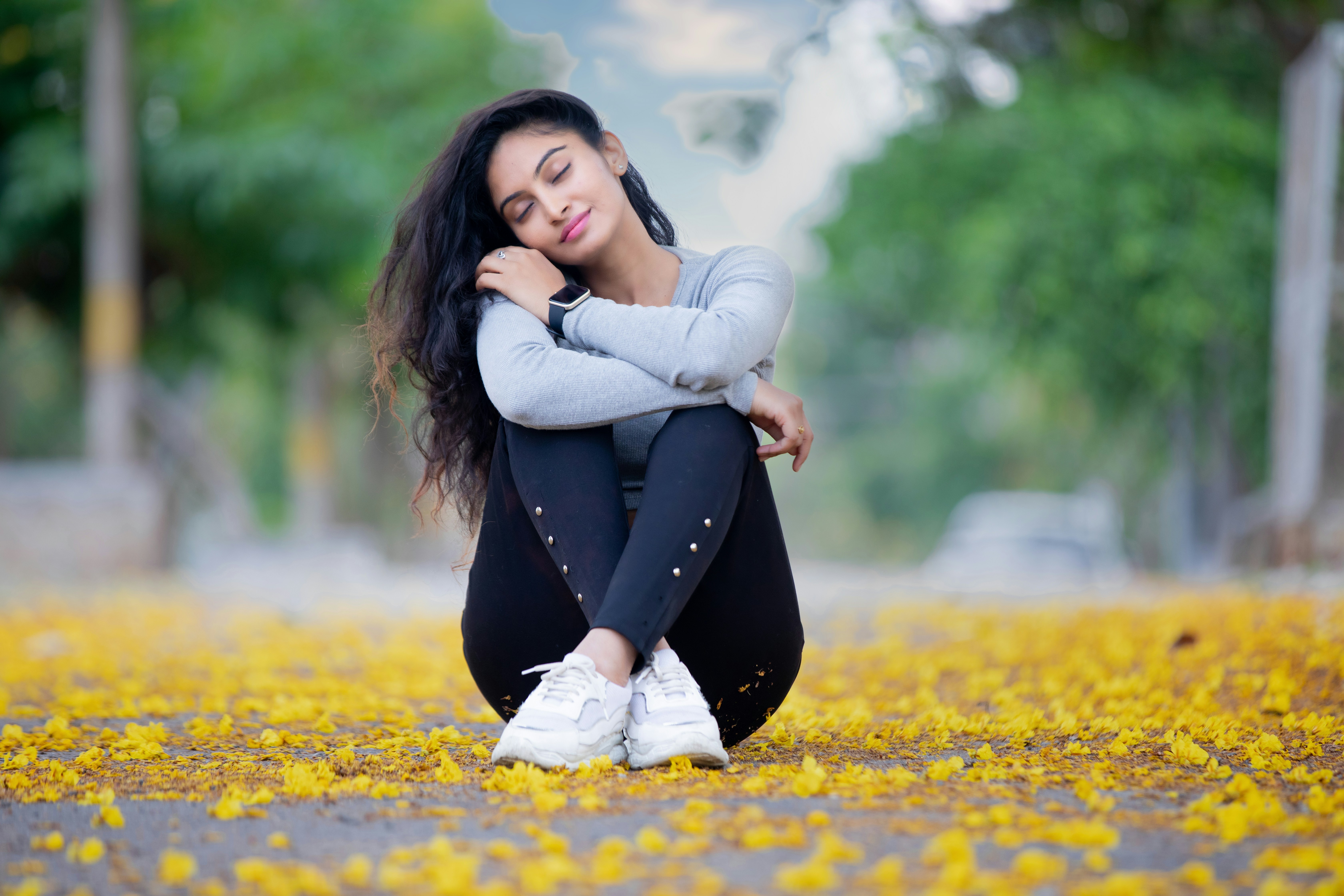 a woman sitting on the ground in a park