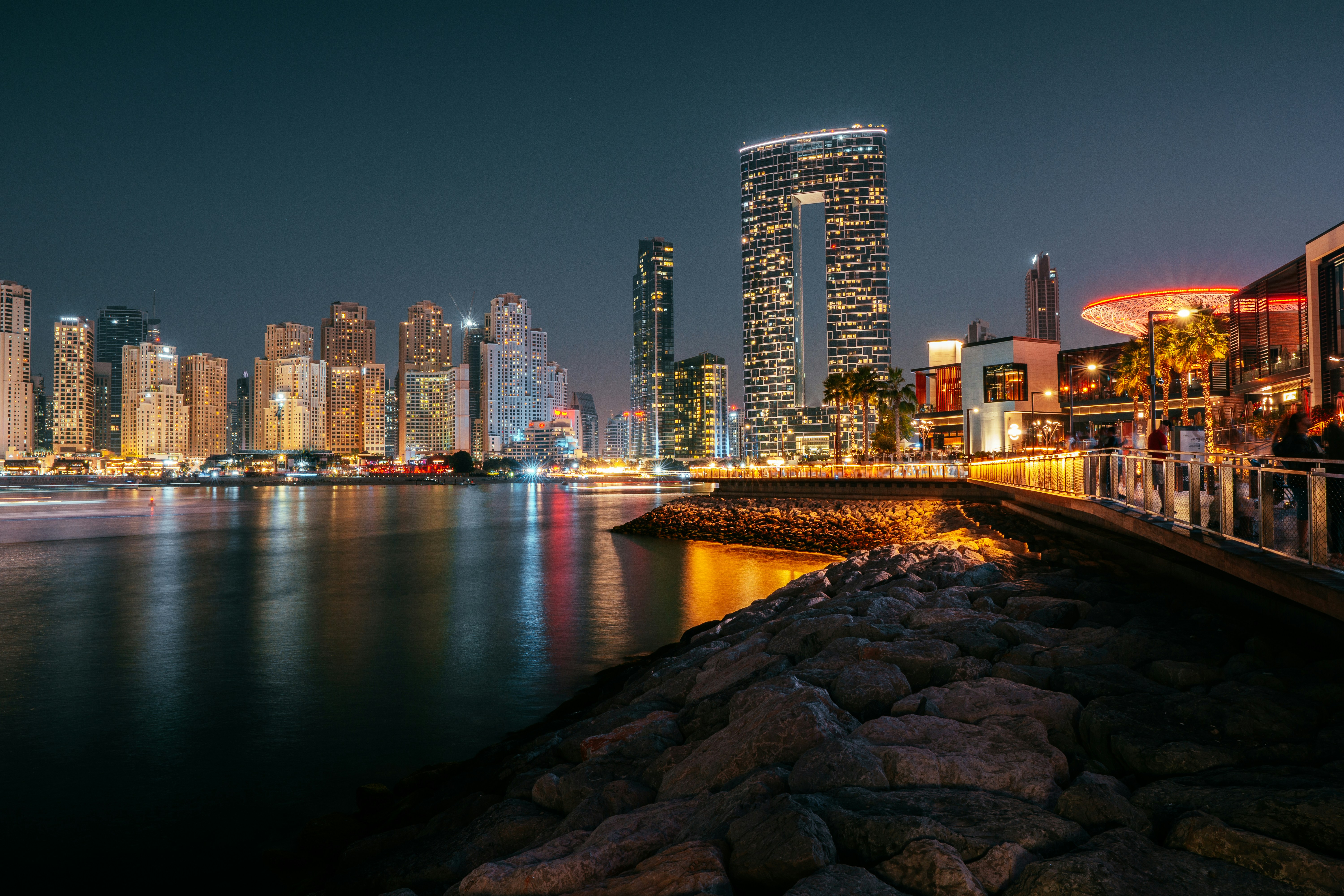 a bridge over a body of water with a city in the background, 
