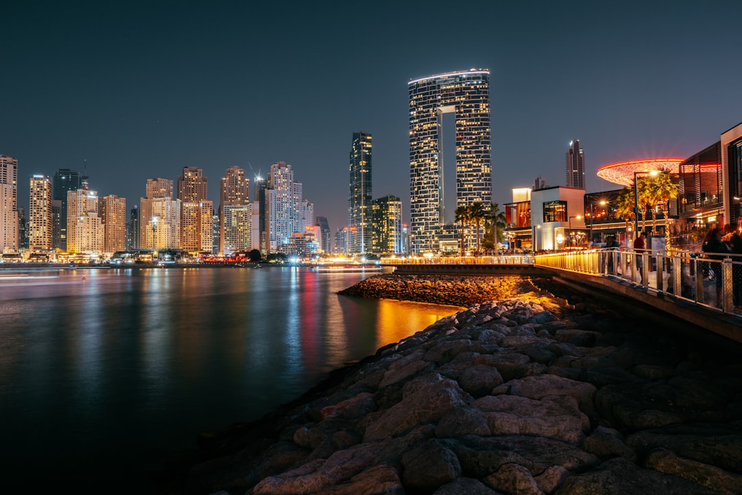 a bridge over a body of water with a city in the background,