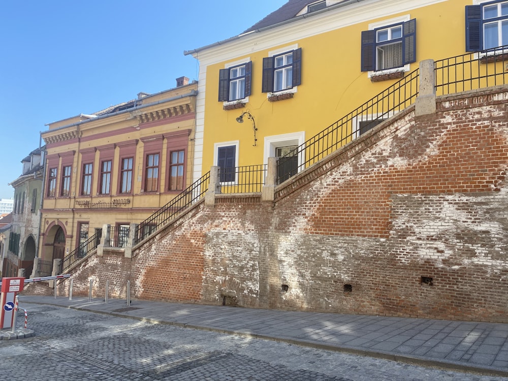 a yellow building with blue shutters and a red fire hydrant