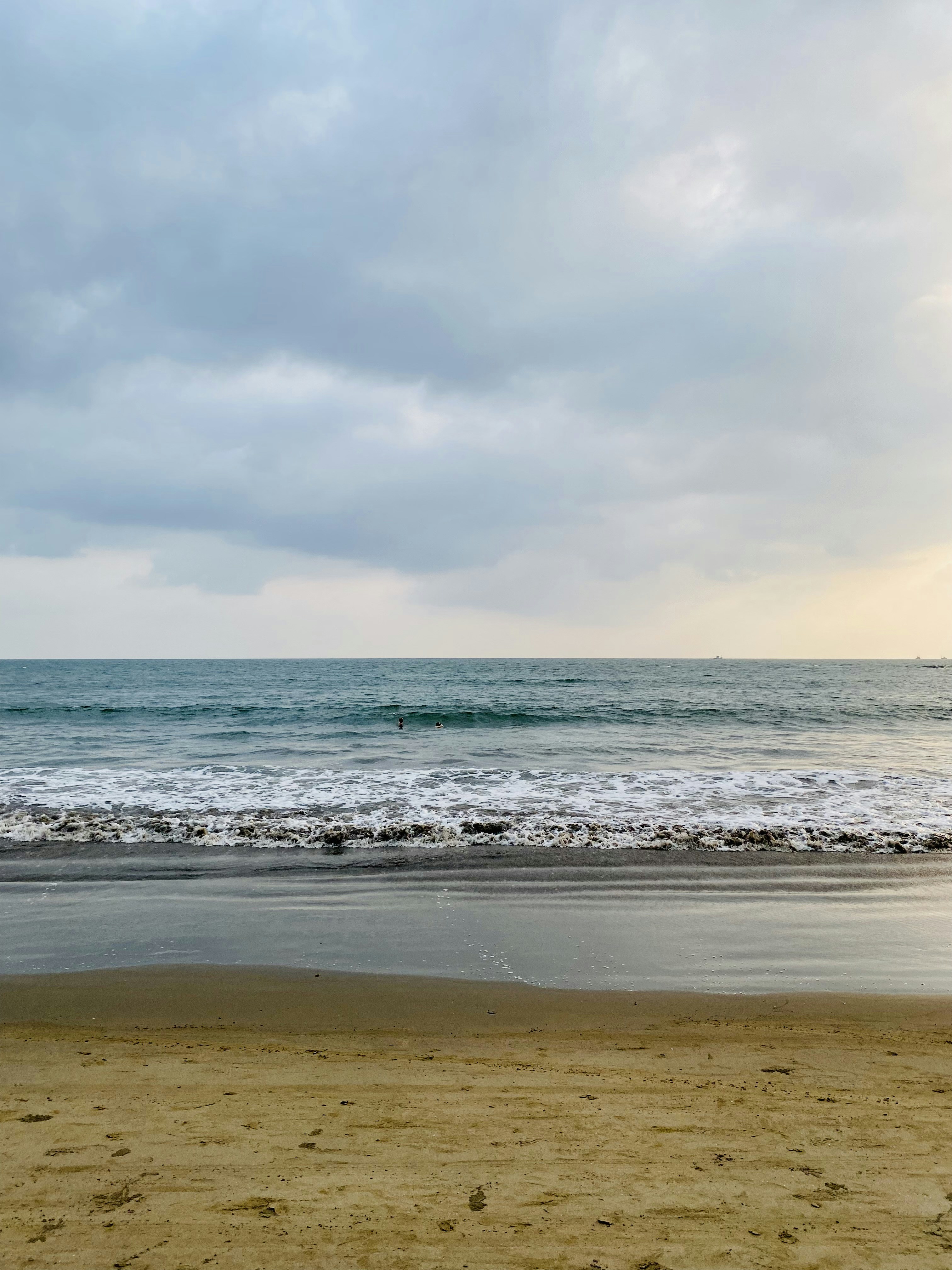 a person walking on the beach with a surfboard