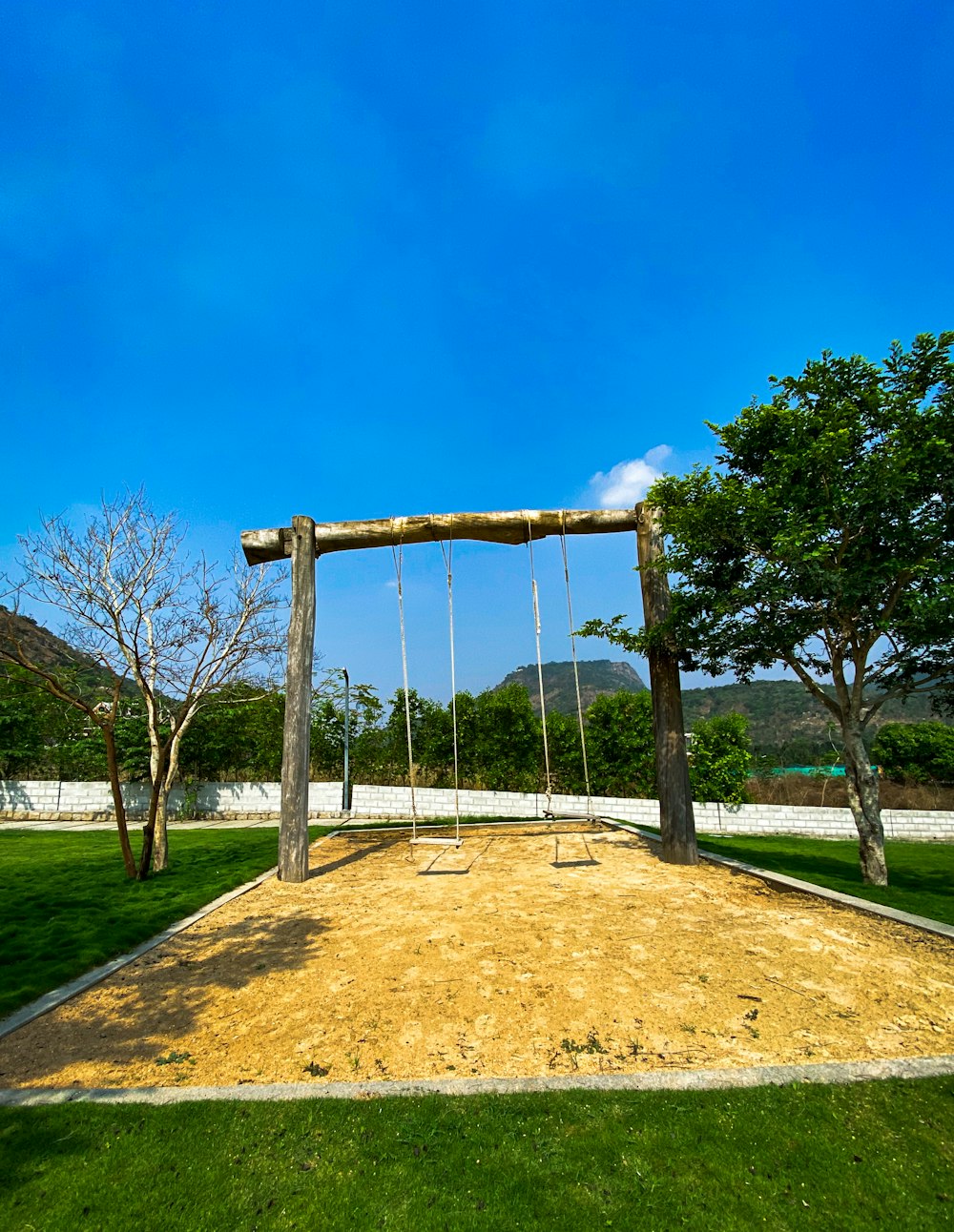 a swing set in the middle of a grassy field