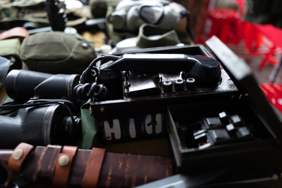 A collection of military-themed apparel and accessories displayed on a rustic wooden table.
