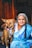 a woman in a blue sari sitting next to a brown dog