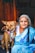 a woman in a blue sari sitting next to a brown dog