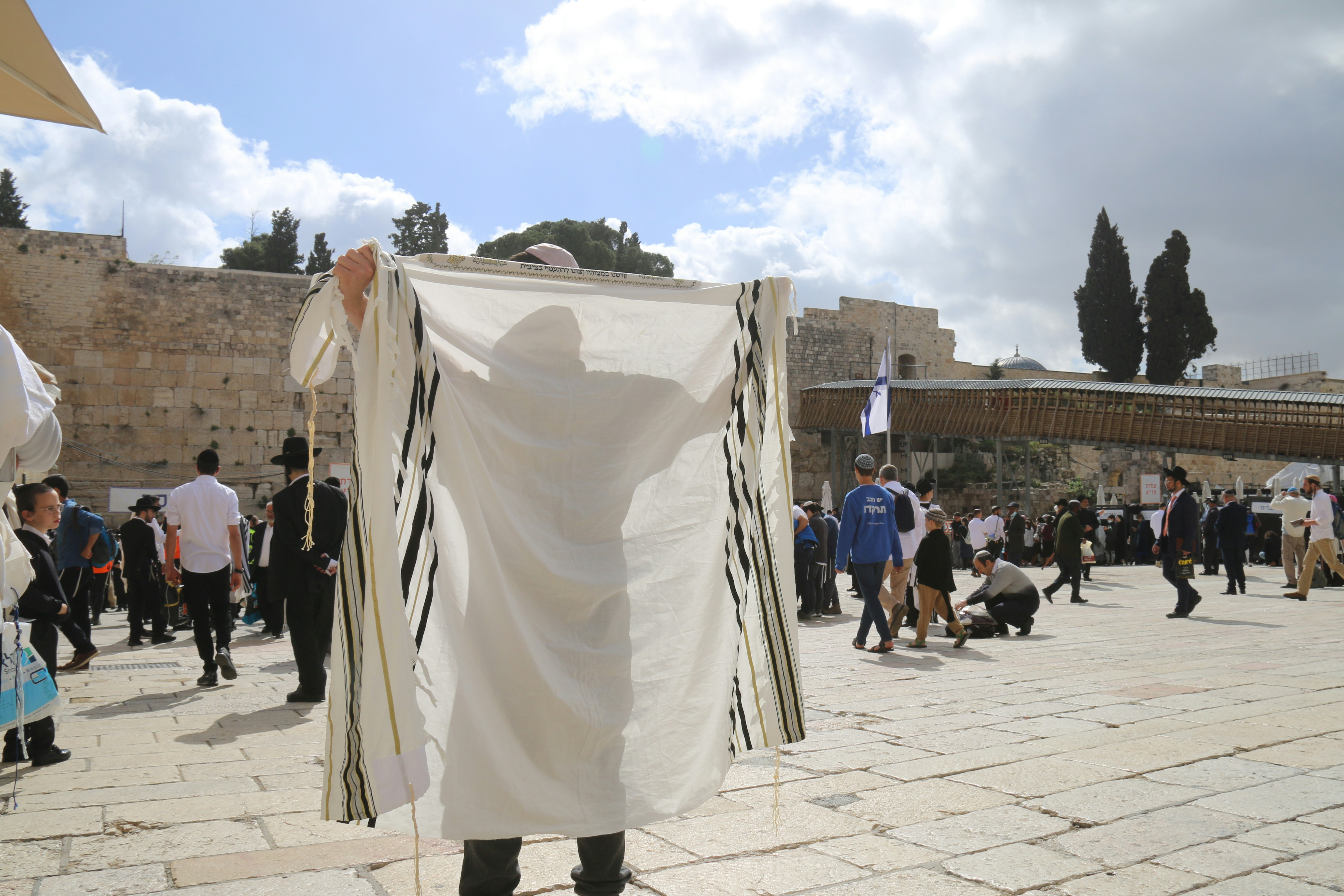 a man holding a white sheet in front of a crowd of people