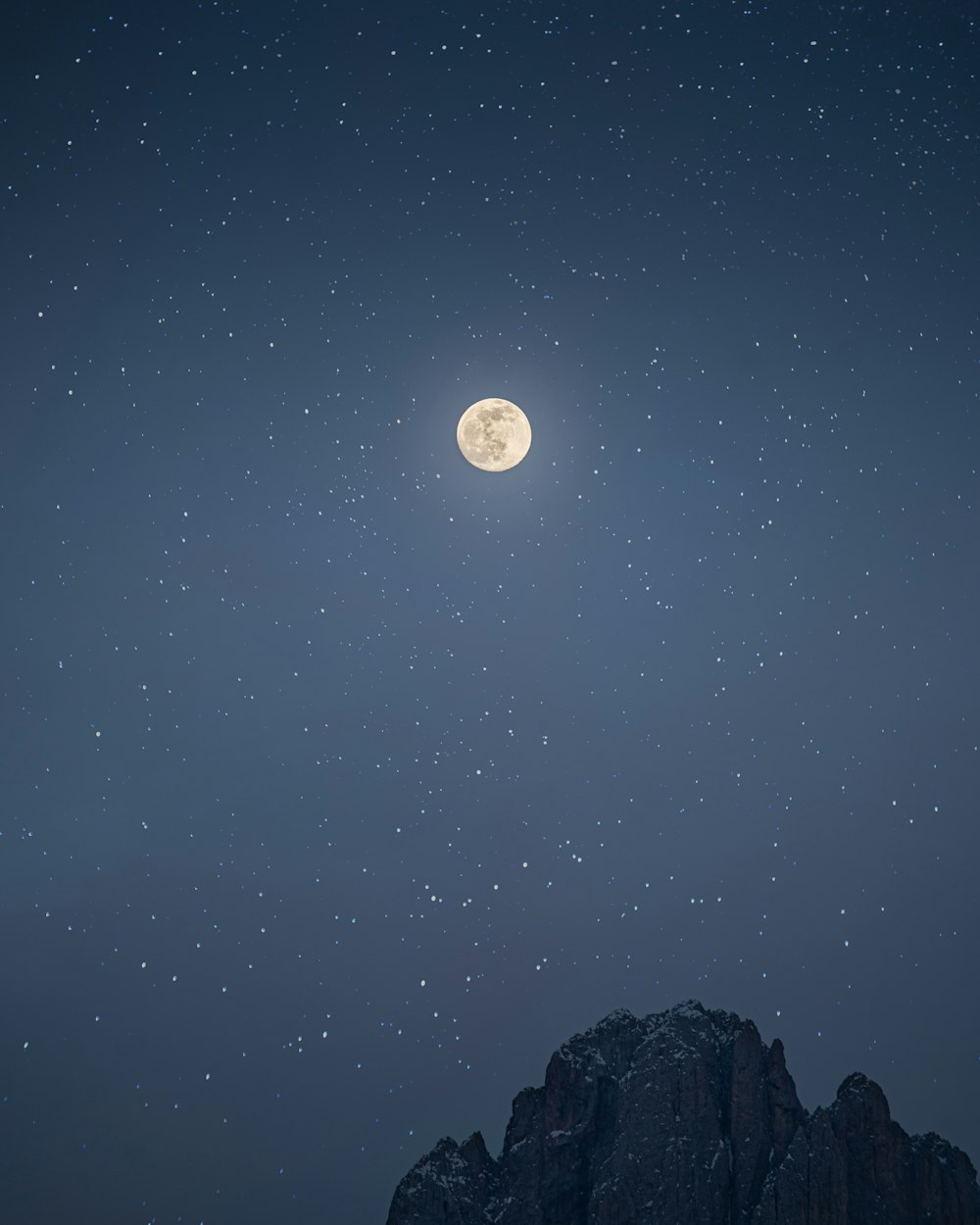 山脈の上に満月が見える