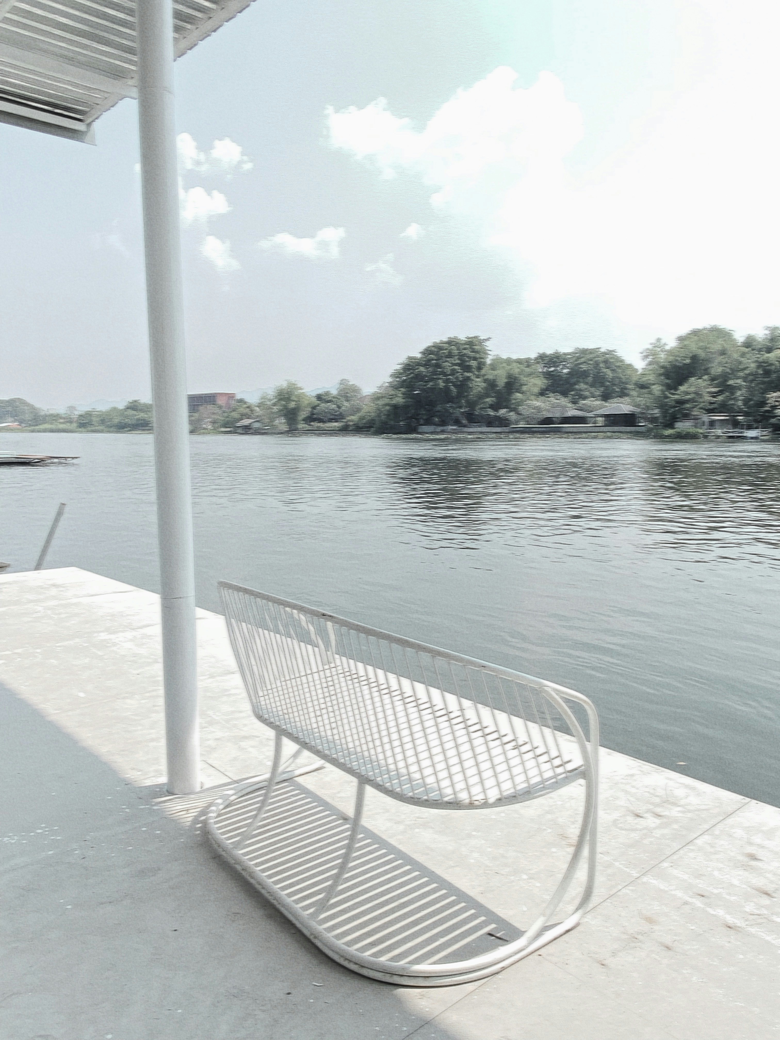 A white bench sitting next to a body of water photo – Free Grey Image ...