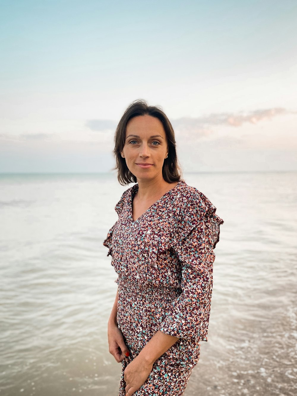 a woman standing on a beach next to the ocean