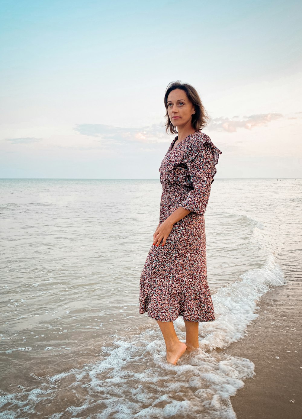 a woman standing in the water at the beach