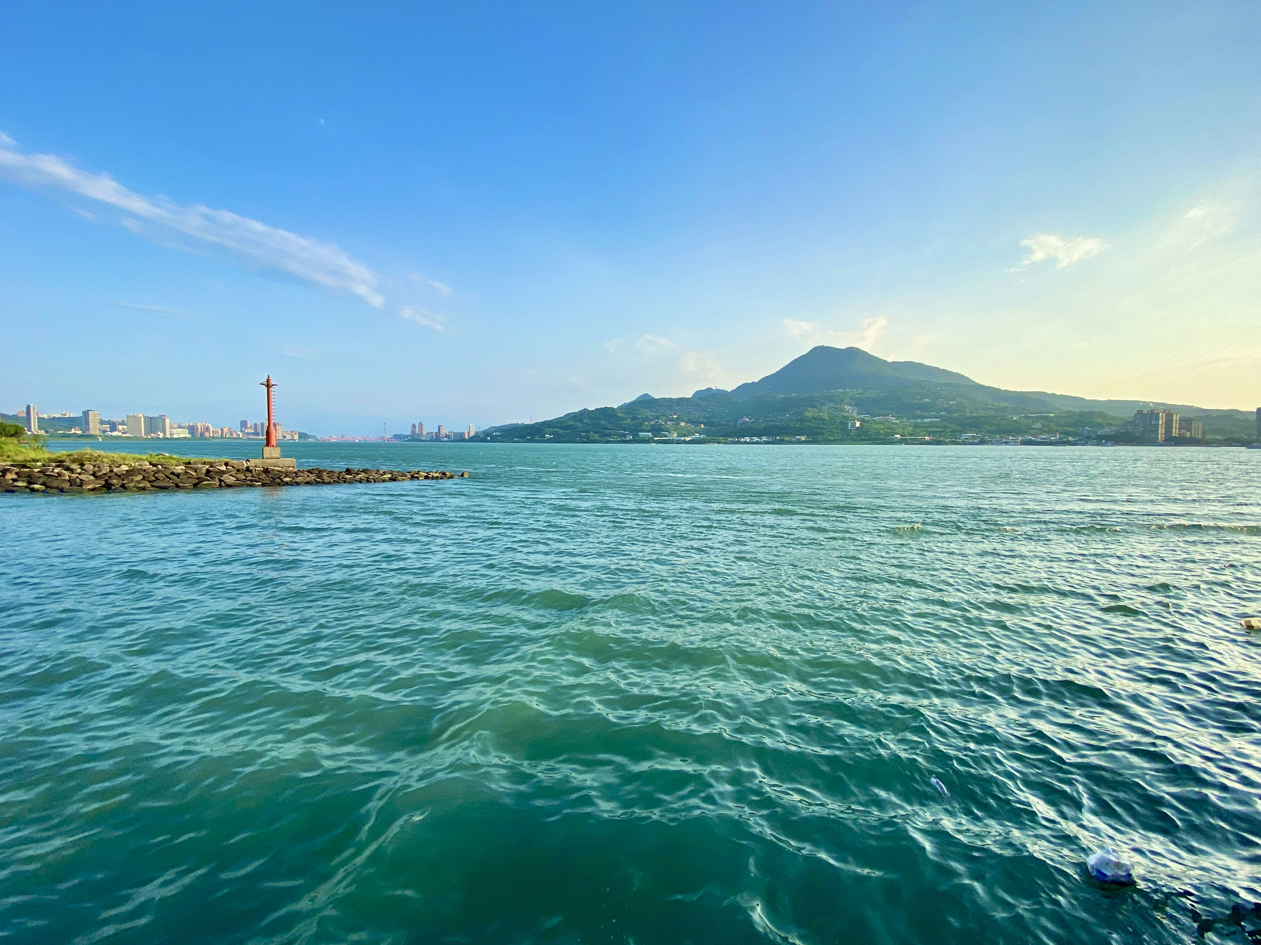 a body of water with a light house in the distance