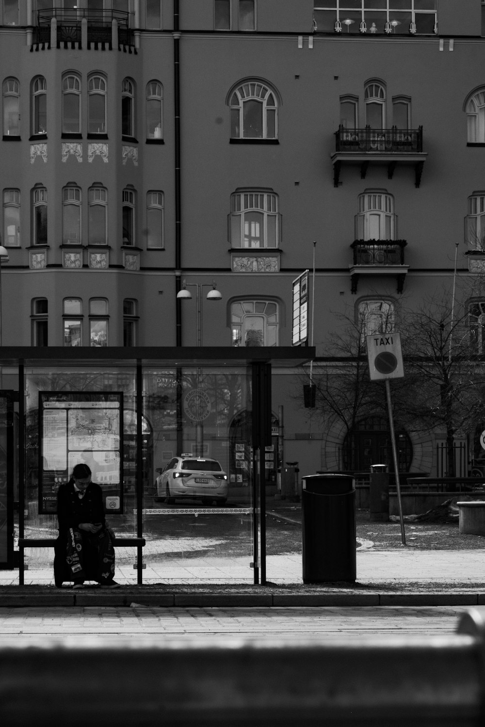 a person sitting on a bench in front of a building