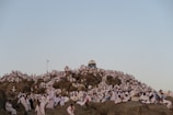 a large group of people sitting on top of a rocky hill