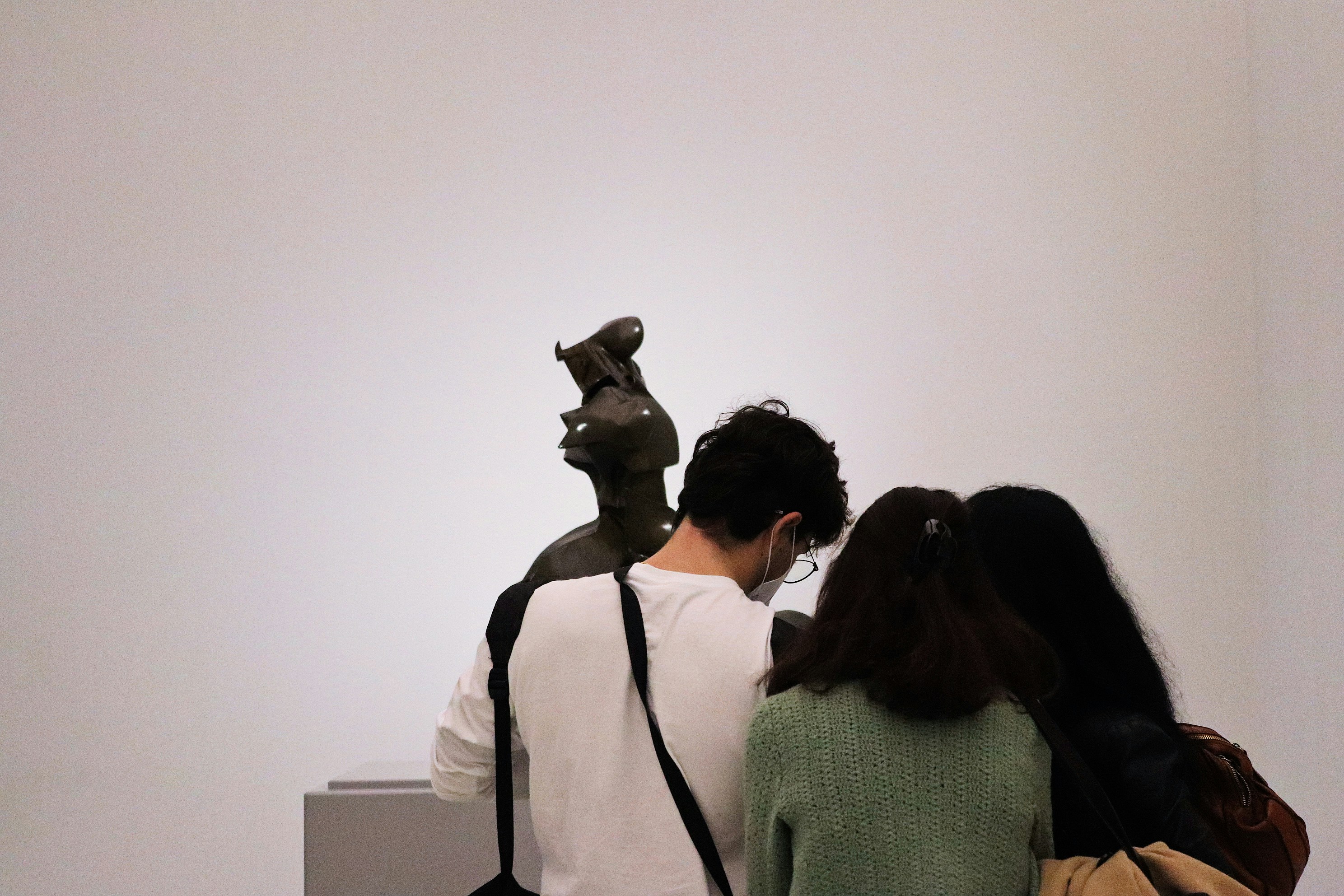 A person thoughtfully looking at a sculpture in a gallery - Art for collectors