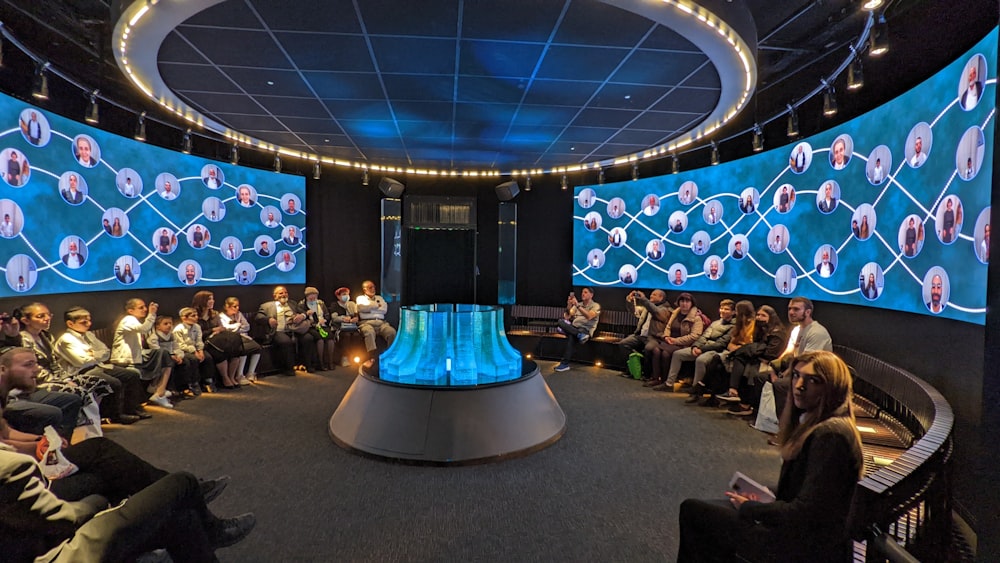 un gruppo di persone sedute davanti a un grande schermo