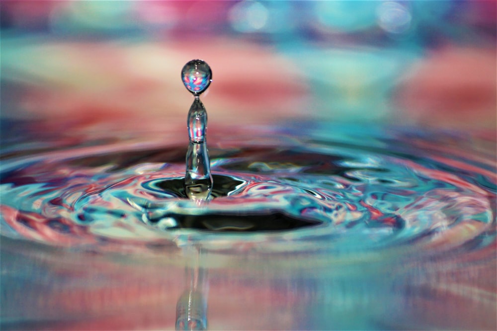 a drop of water with a colorful background