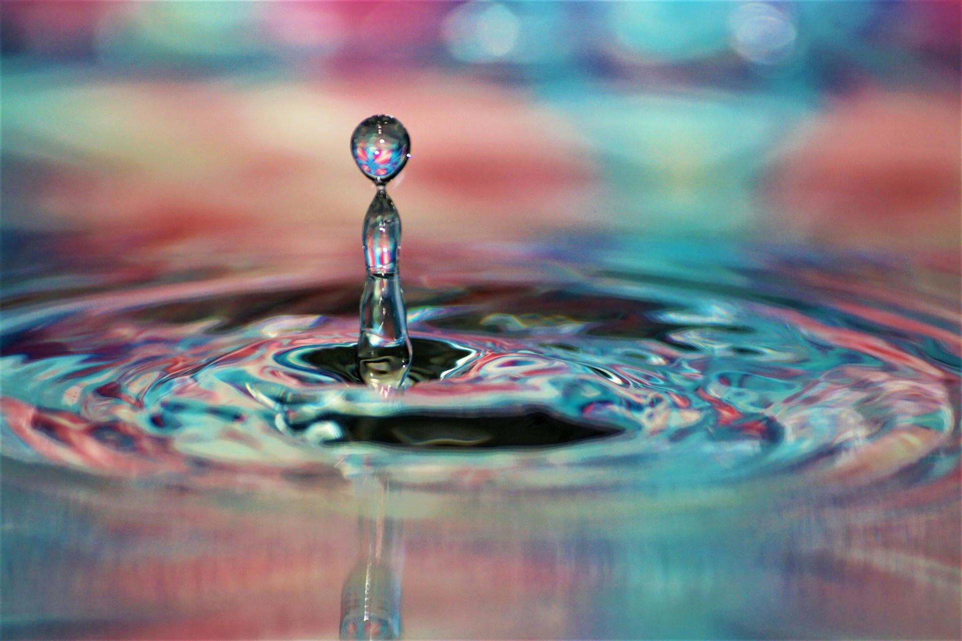 a drop of water with a colorful background