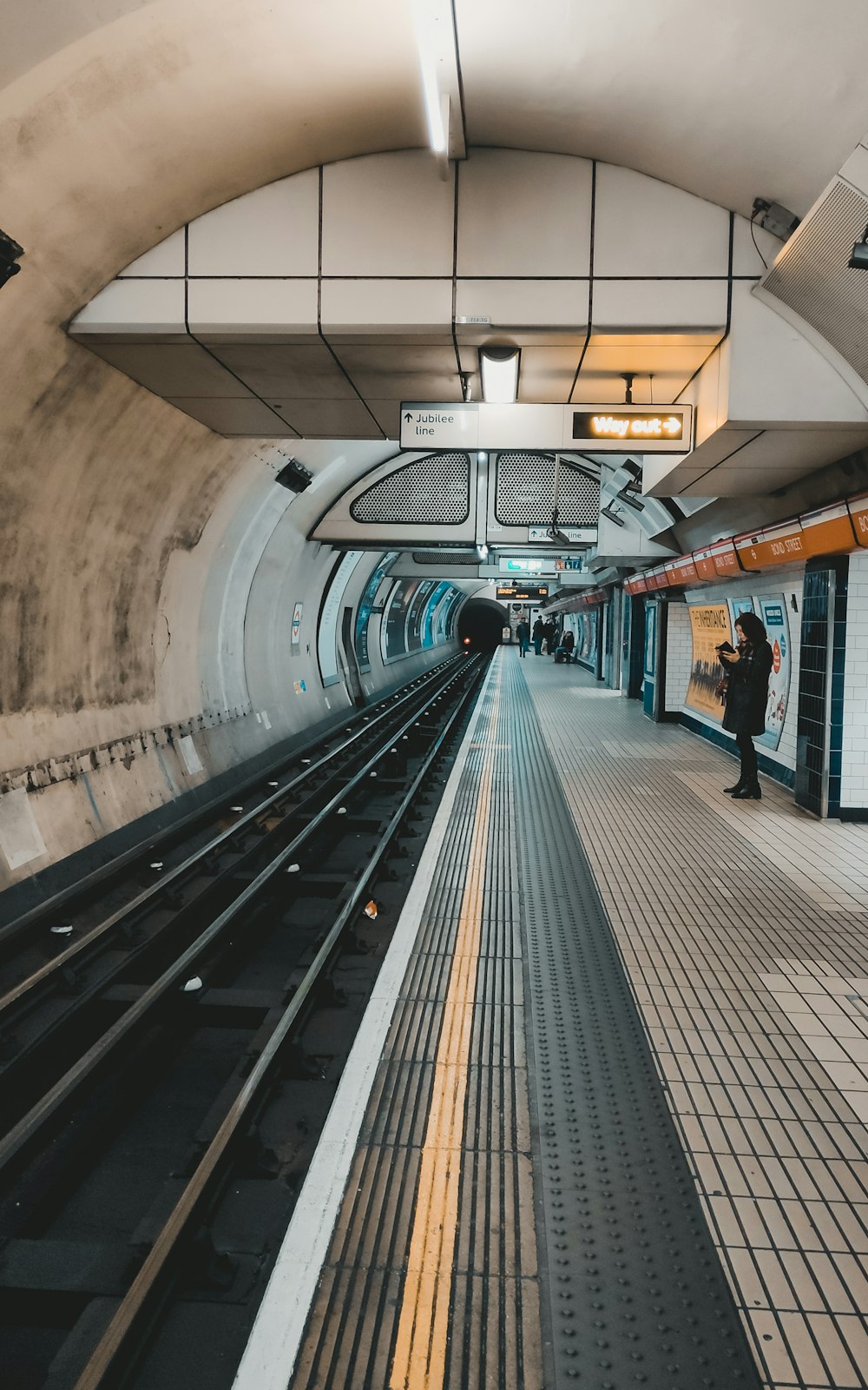 a train station with a person standing on the platform