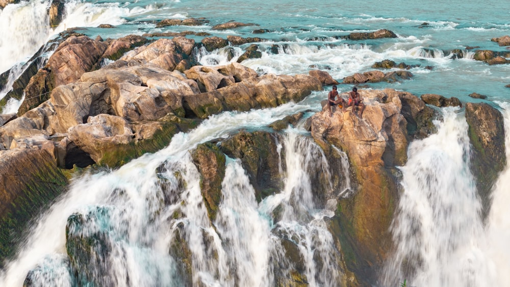 a group of people standing on top of a waterfall