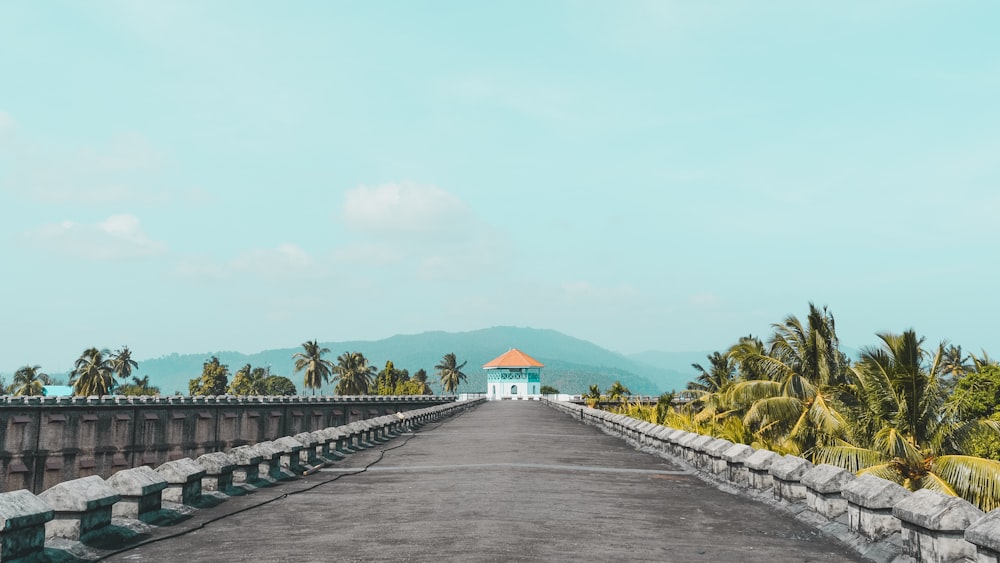 uma estrada vazia com um edifício branco à distância