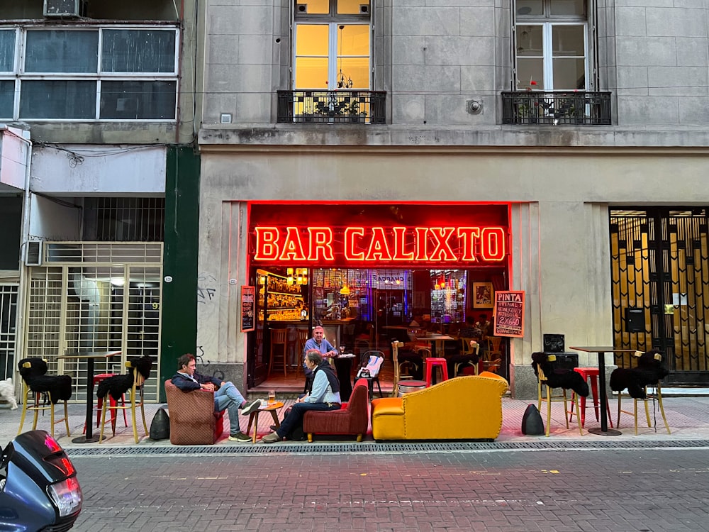 quelques personnes assises à l’extérieur d’un bar