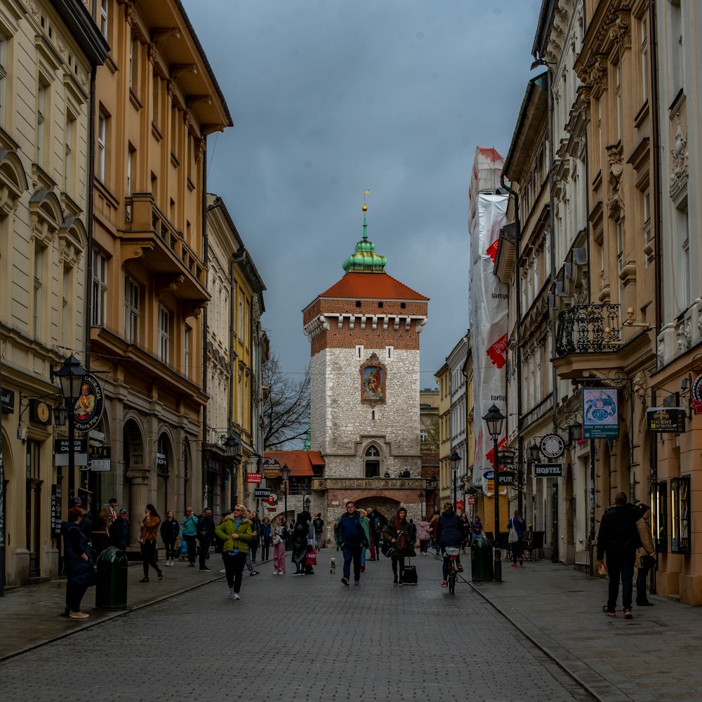 a group of people walking down a street next to tall buildings