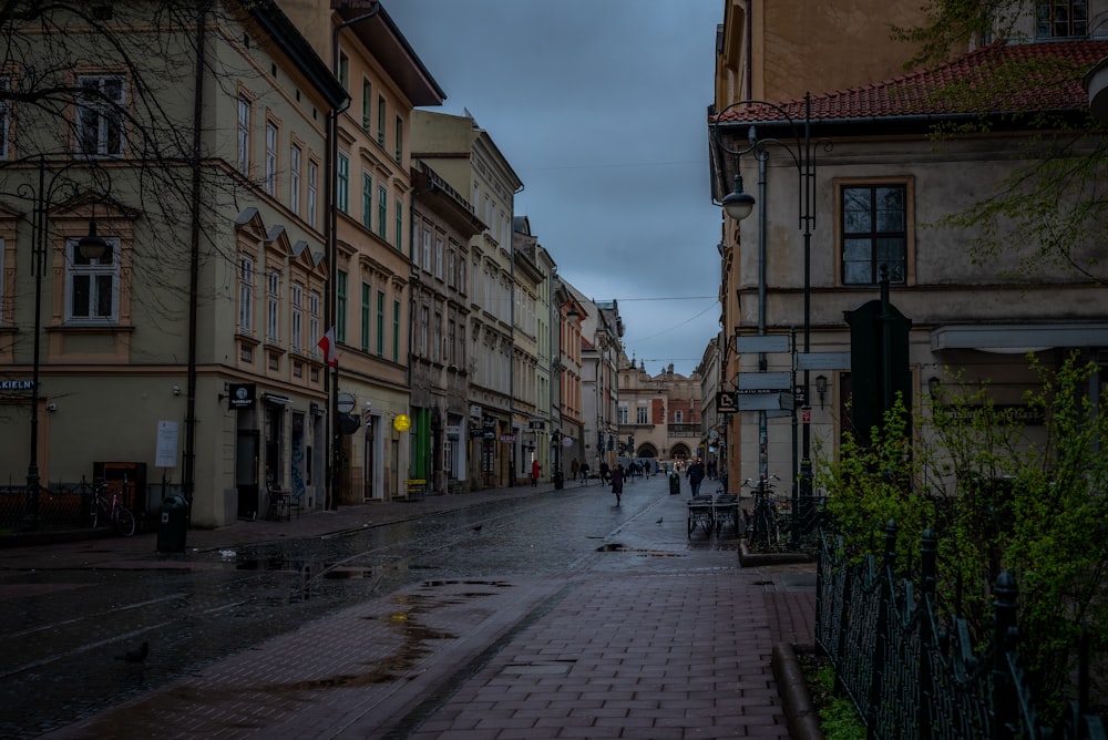 a city street with a few people walking down it