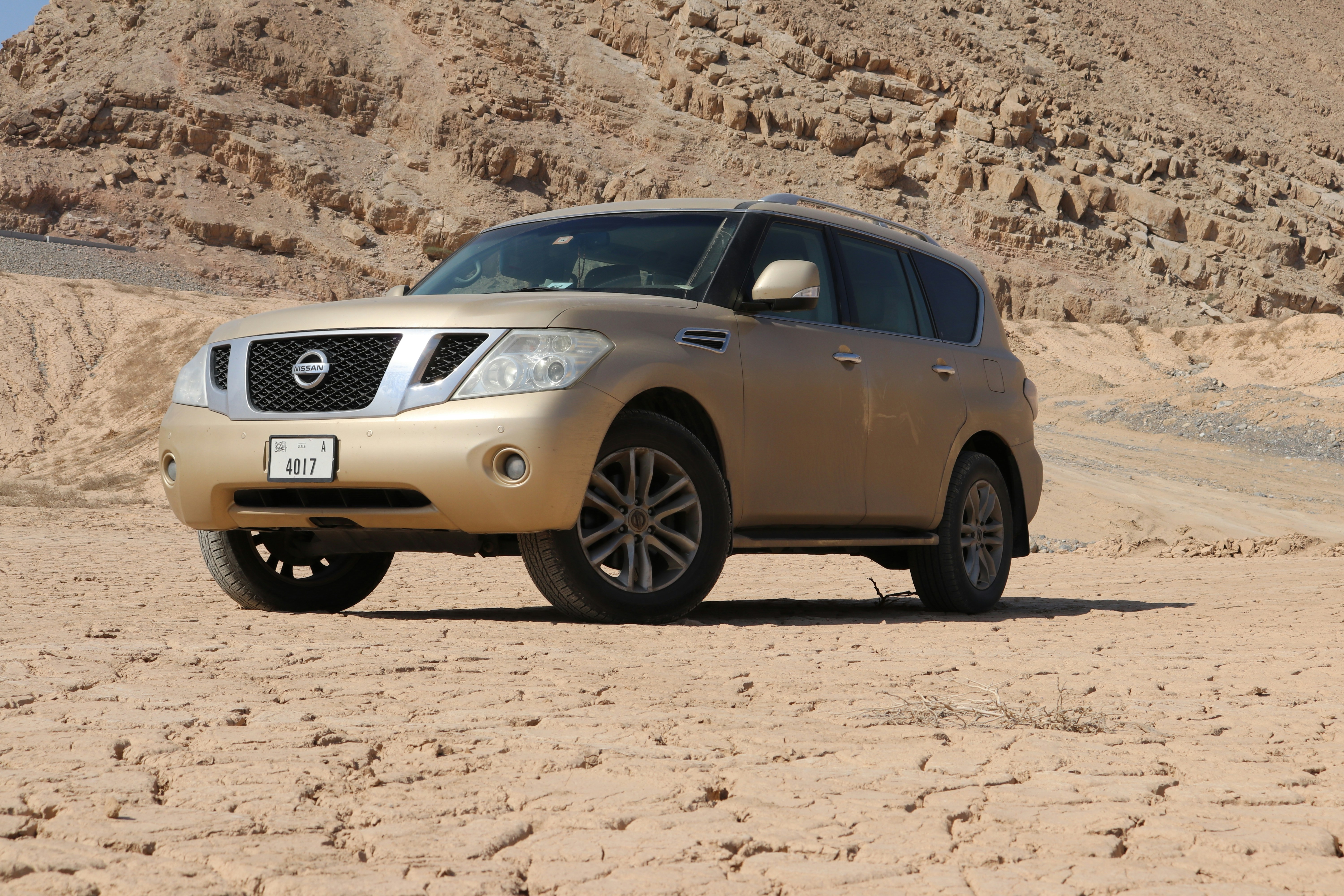 Gold Nissan Patrol SUV parked in the desert