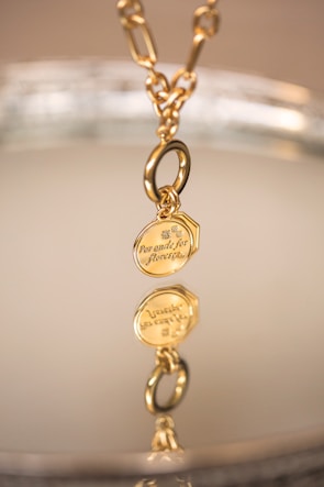 Modern gold pendant design rendered with smooth curves and polished finish.