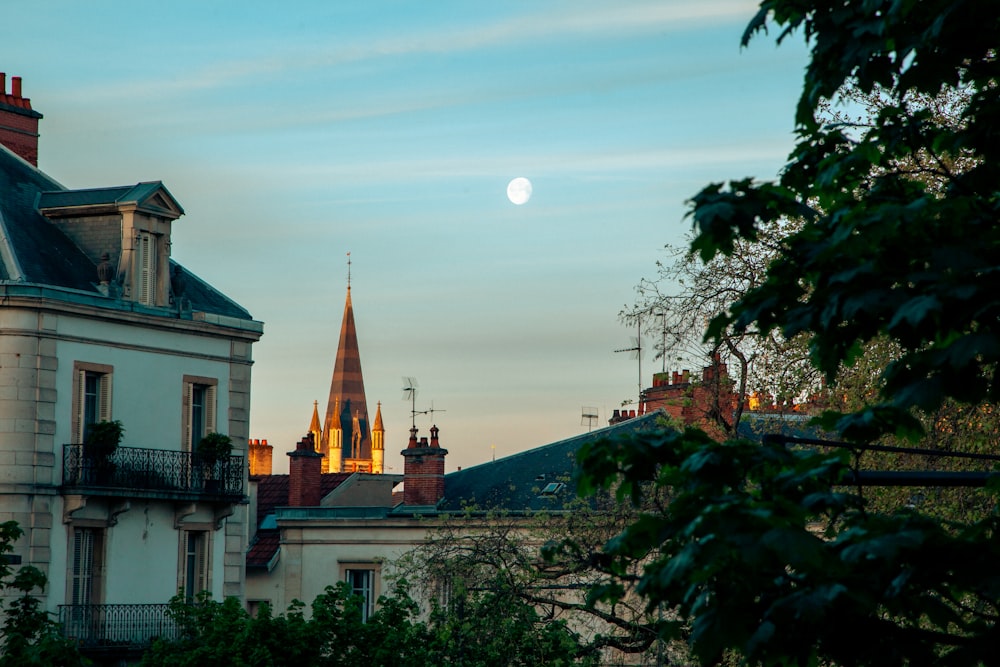a full moon rises over a city skyline