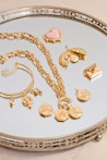 a silver tray topped with lots of gold jewelry