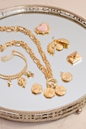 a silver tray topped with lots of gold jewelry