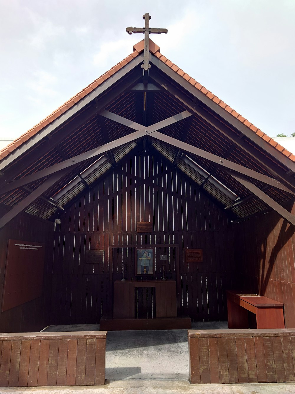 a wooden church with a cross on top of it
