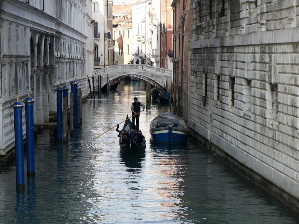 a man riding a boat down a narrow canal