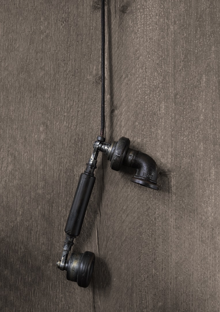 a pair of black hoses attached to a wooden wall